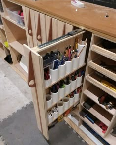 a wooden shelf filled with lots of pens and pencils