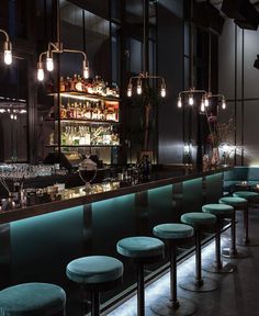 a dimly lit bar with stools and lights