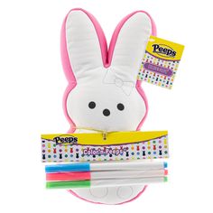 a stuffed bunny with pens in it's mouth and some other items around it