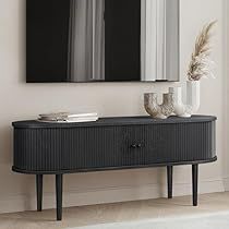 a black cabinet with two mirrors on the wall above it and a vase in front of it