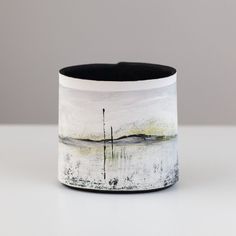 a white and black vase sitting on top of a table