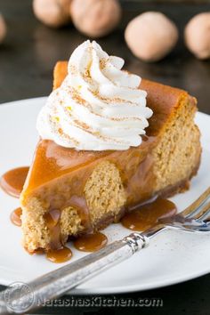 a slice of pumpkin cheesecake on a plate with whipped cream and caramel sauce