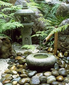 a stone fountain surrounded by rocks and plants