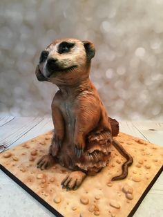 a small toy meerkat sitting on top of a wooden board with bubbles in the background