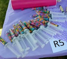 the table is covered with many different colored pens and pencils in plastic containers on it