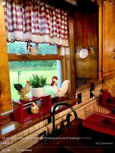 a kitchen with a sink, window and rooster figurines