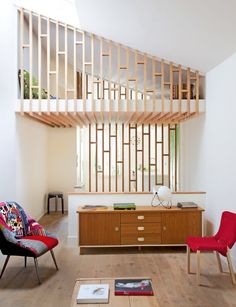 a living room filled with lots of furniture and wooden flooring next to a staircase