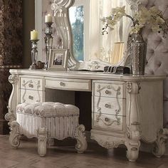 an antique white dressing table with mirror and stool