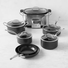 an assortment of pots and pans sitting on a table with the lid open to show what's cooking in them