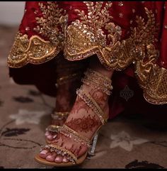 a woman's feet in gold and red shoes