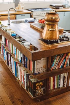 a kitchen island with books on it in front of a sink