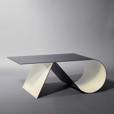 a glass table with an unusual design on it's top and curved edges, against a gray background