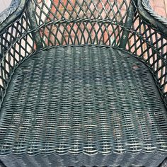 a green bench sitting on top of a brick floor next to a wall and sidewalk