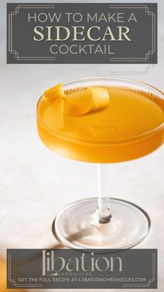 a glass filled with an orange drink on top of a table