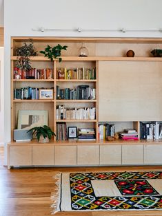 a living room filled with lots of furniture and bookshelves on top of wooden shelves