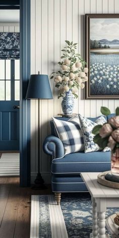 a blue and white living room with flowers on the coffee table in front of it