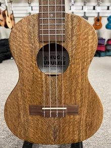 a wooden ukulele sitting on top of a stand