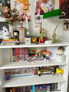 a white book shelf filled with books and figurines