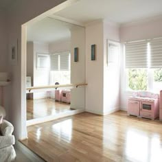 a living room with hardwood floors and pink furniture