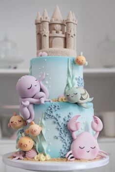 a three tiered cake decorated with sea animals and under the sea theme is shown