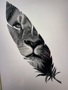 a black and white photo of a lion's face with a feather on it