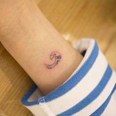 a woman's wrist with a small wave tattoo on the left side of her arm