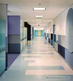 an empty hospital hallway with blue and yellow painted walls on both sides, and lockers at the end