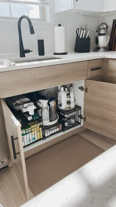 an open cabinet in a kitchen with dishes and utensils