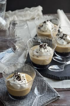 small desserts with whipped cream and chocolate toppings in glass bowls on a tray