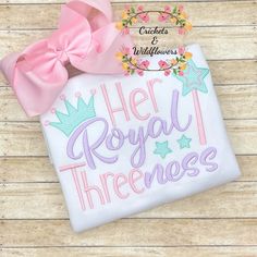 a white shirt that says her royal threeness with a pink bow