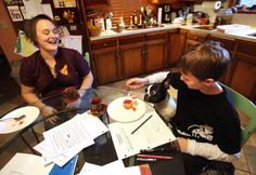 a woman and boy sitting at a table with food in front of them on plates