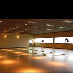 an empty room with lights on the ceiling and windows in the wall to let people know what they are doing