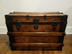 an old wooden trunk sitting on top of a hard wood floor