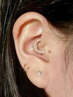 a close up of a person's ear with two piercings on top of it