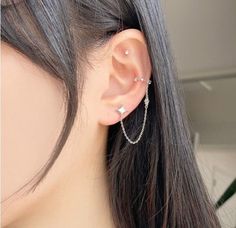 a close up of a person's ear with a chain attached to the side