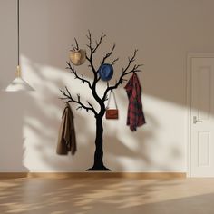 a tree with several coats hanging from it's branches in front of a door