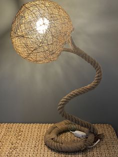 a lamp that is sitting on top of a table next to a roped light