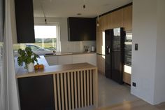 a kitchen with black and white cabinets, wood flooring and an island in the middle