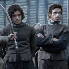 two men standing next to each other with swords in their hands and one holding a bow