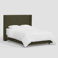 a bed with a green headboard and white sheets