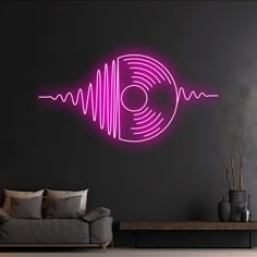 a living room with a couch, coffee table and neon pink wall decal in the shape of a vinyl record