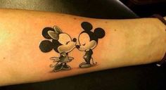 mickey and minnie mouse tattoo on the arm, which has been drawn in black ink