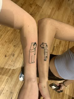 two people with matching tattoos on their arms, one has a dog and the other has a cat