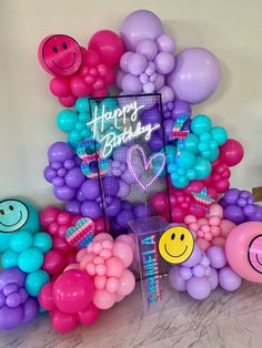 balloons are arranged around a happy birthday sign