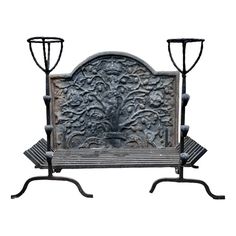 an old iron bench with two candles on each side and a statue in the middle