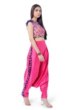 Hot pink crop top with embroidery and tassels. Comes with bandhani print low crotch pants.
Component: 2
Pattern: Embroidery and Print
Type Of Work: Thread and Bandhani Print
Neckline: Round
Sleeve Type: Sleeveless
Fabric: Georgette and Silk
Color: Pink
Other Details: 
Pants with tassel detail at the sides
Side pockets
Scalloped hem
Closure: Hook back
Note: Sling bag carried by the model is not for sale
Occasion: Destination Wedding - Aza Fashions Crop Top With Pants, Low Crotch Pants, Top With Pants, Bandhani Print, Payal Singhal, Pink Thread, Embroidery Print, Embroidered Crop Tops, Pink Crop Top