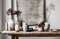 several vases are sitting on a wooden table