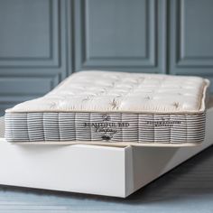 an image of a mattress on the bottom of a bed frame in front of a blue wall