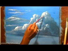 someone is painting clouds in the sky with colored pencils