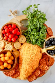 a platter filled with meat, veggies and crackers next to olives